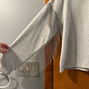 Adorable, soft sweatshirt with metal fringe on the sleeves.